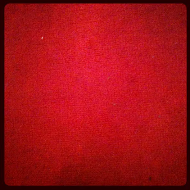 A close-up of plain red carpet