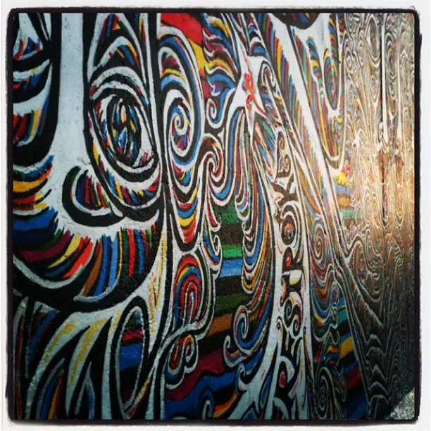 Colourful swirling street art on a long concrete wall