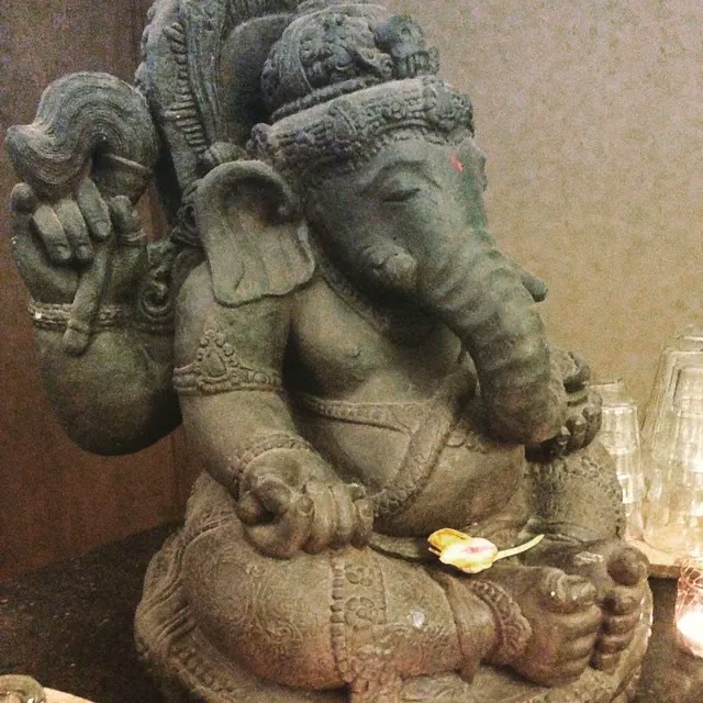 A stone statue of Ganesha, seated