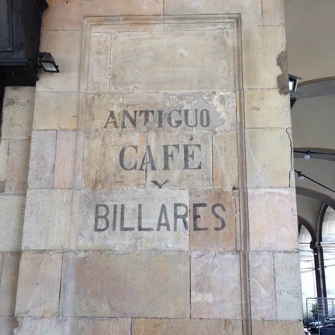 Letrero antiguo pintado en un muro de piedra: Antiguo Café y Billares