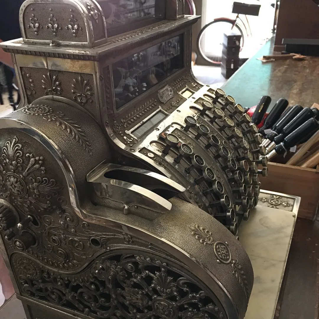 An ornate antique cash register on a shop counter