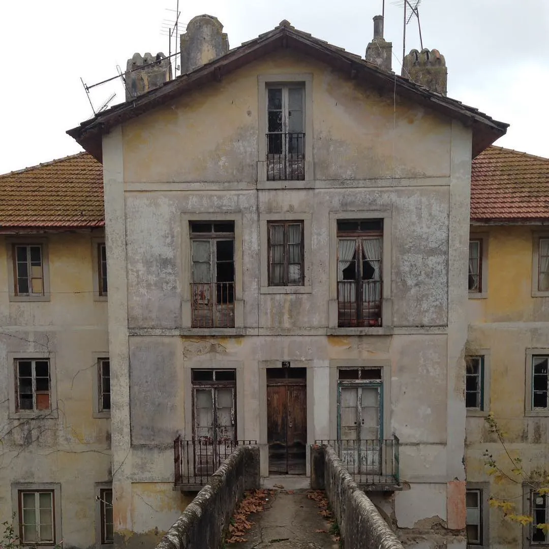Una casa antigua de tres plantas, con la fachada descascarada, en Sintra