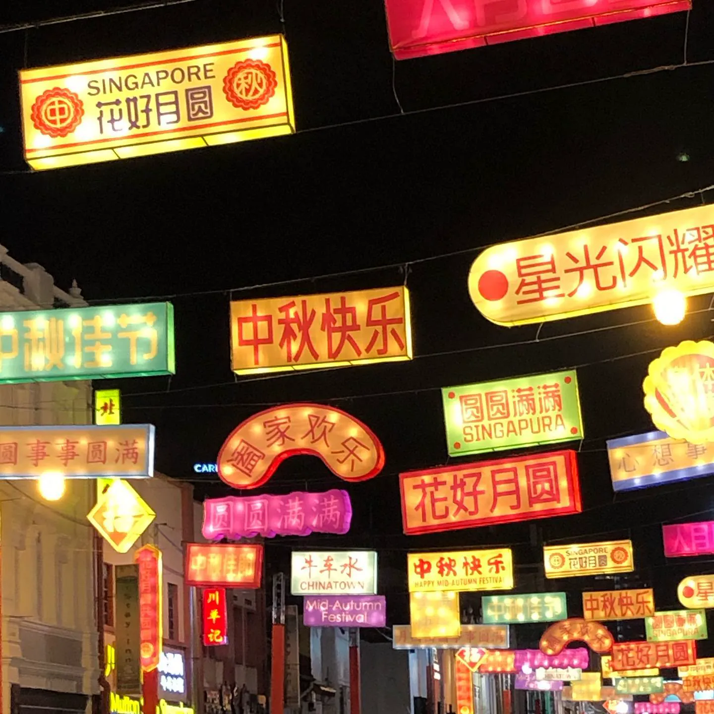 Neon signs and lanterns in Chinatown, Singapore, at night during the Mid-Autumn Festival